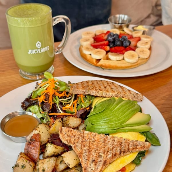 A Juicy Ladies matcha latte, a waffle with fruit, and a healthy breakfast plate with avocado toast.